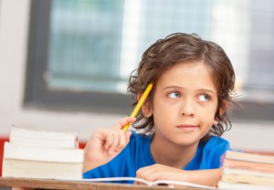 Young boy at school thinking about problem solution. Inspiration concept.